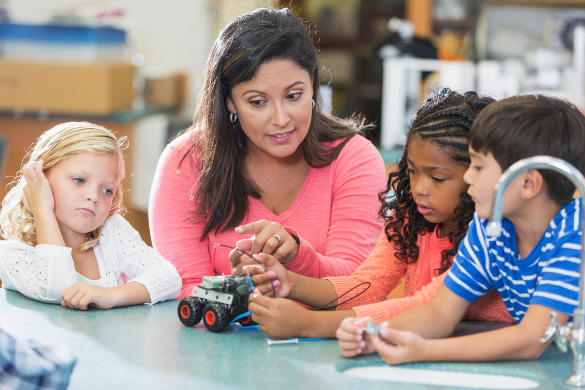 Hispanic science teacher teaching elementary school