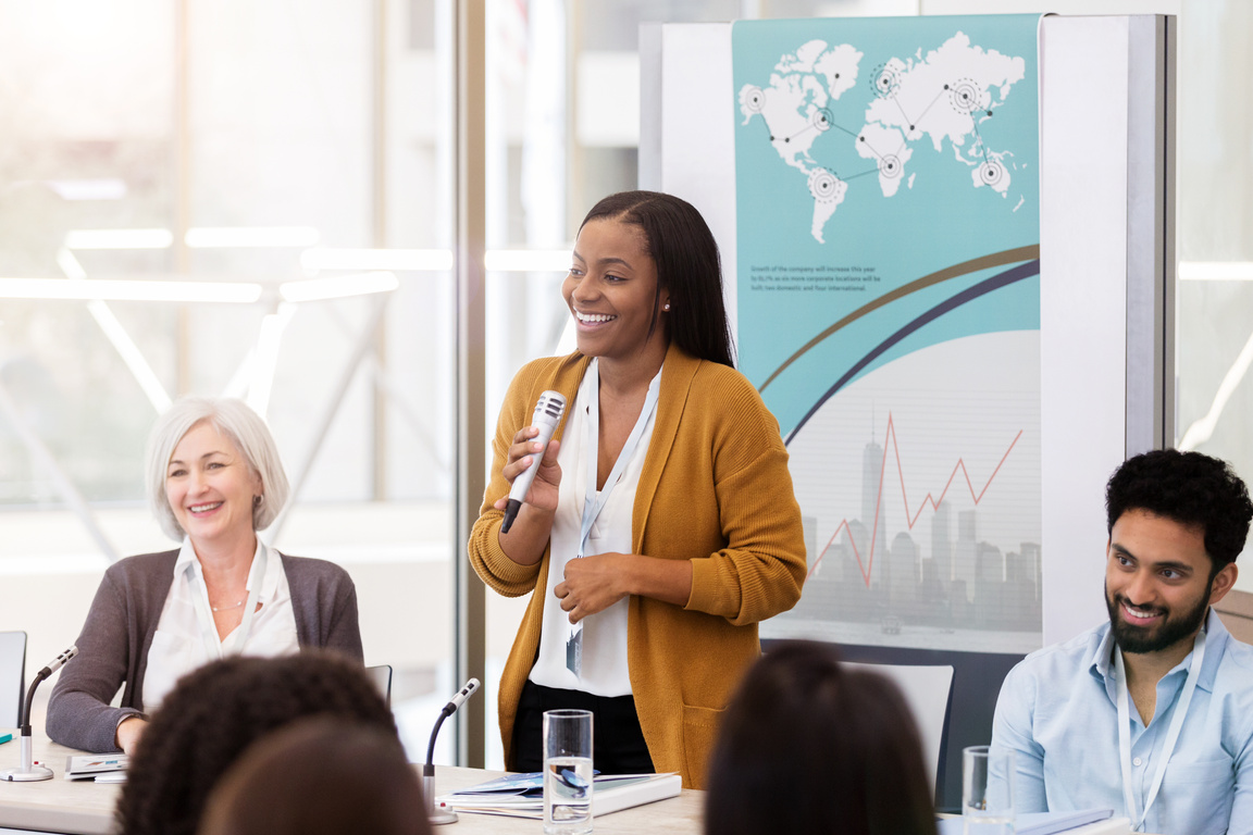 Woman with a Microphone Leading a Meeting 